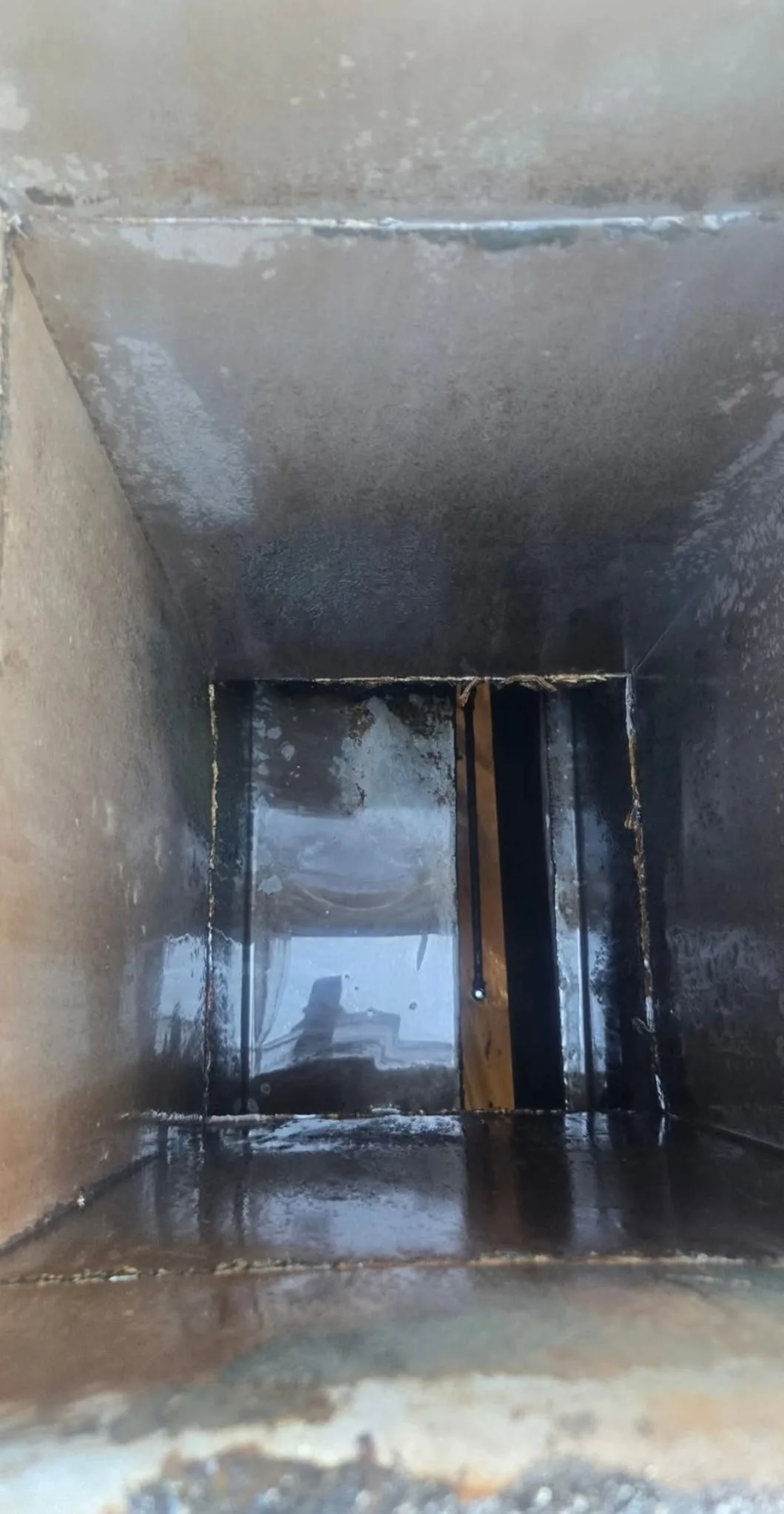 Commercial hood duct interior after cleaning with grease fully removed from all surfaces