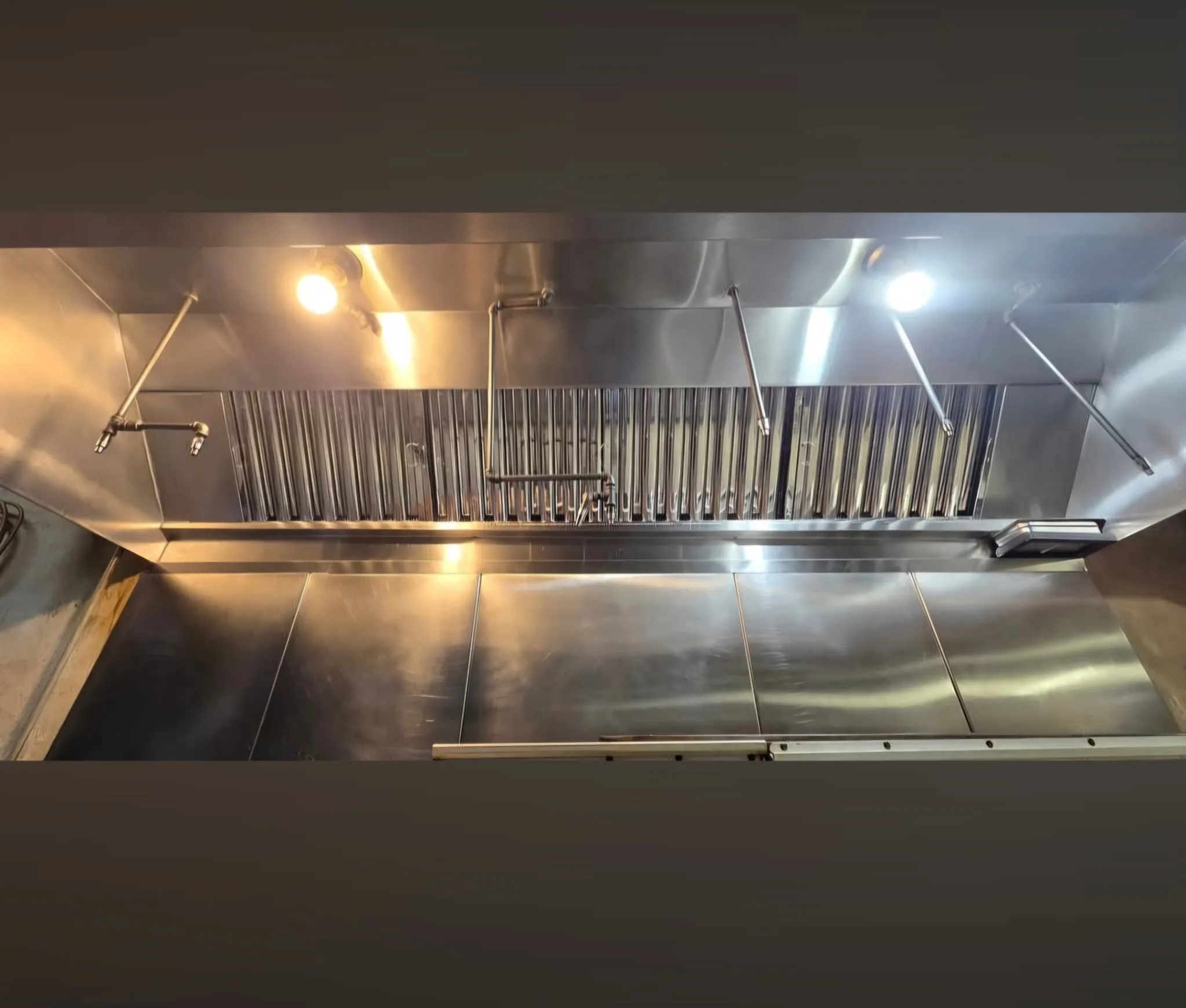 Commercial kitchen hood baffle filters after cleaning showing clean stainless steel