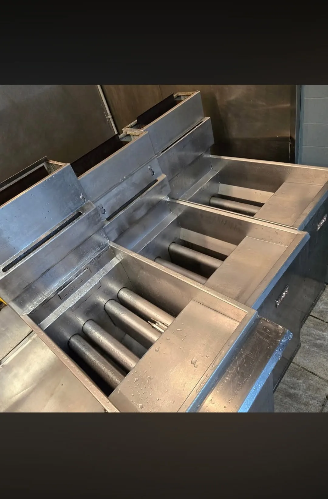 Commercial fryer vats after cleaning showing clean polished stainless steel interior