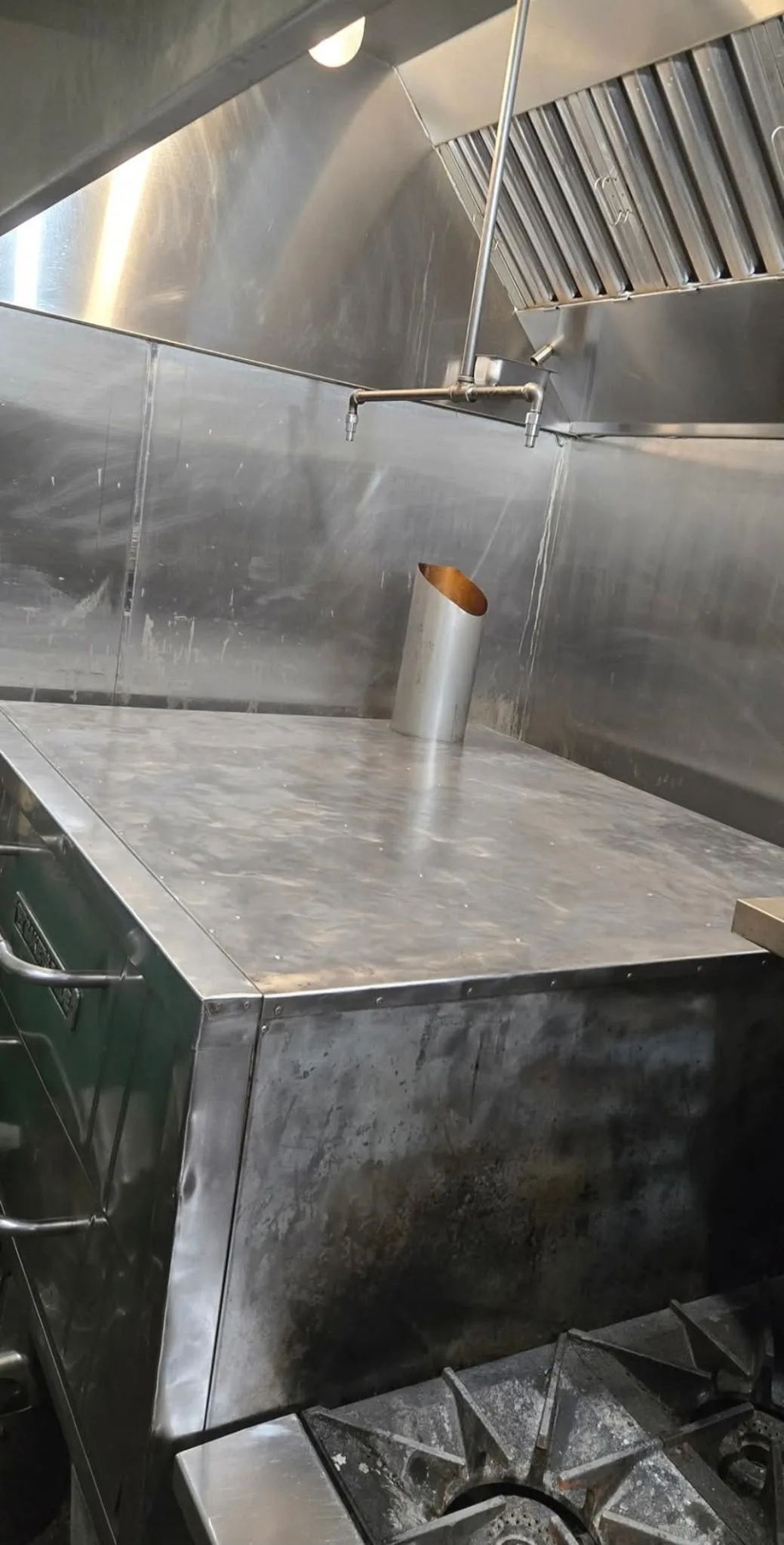 Wide shot of commercial kitchen equipment after cleaning fully restored
