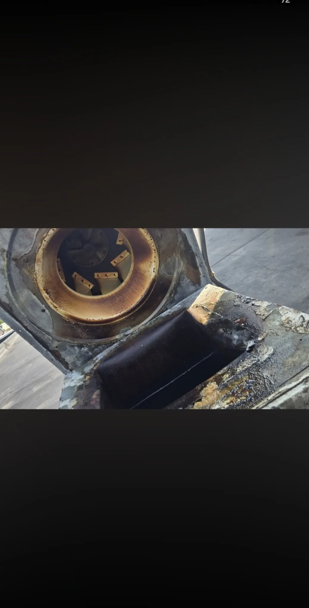 Commercial rooftop exhaust fan wheel before cleaning heavily coated in grease buildup