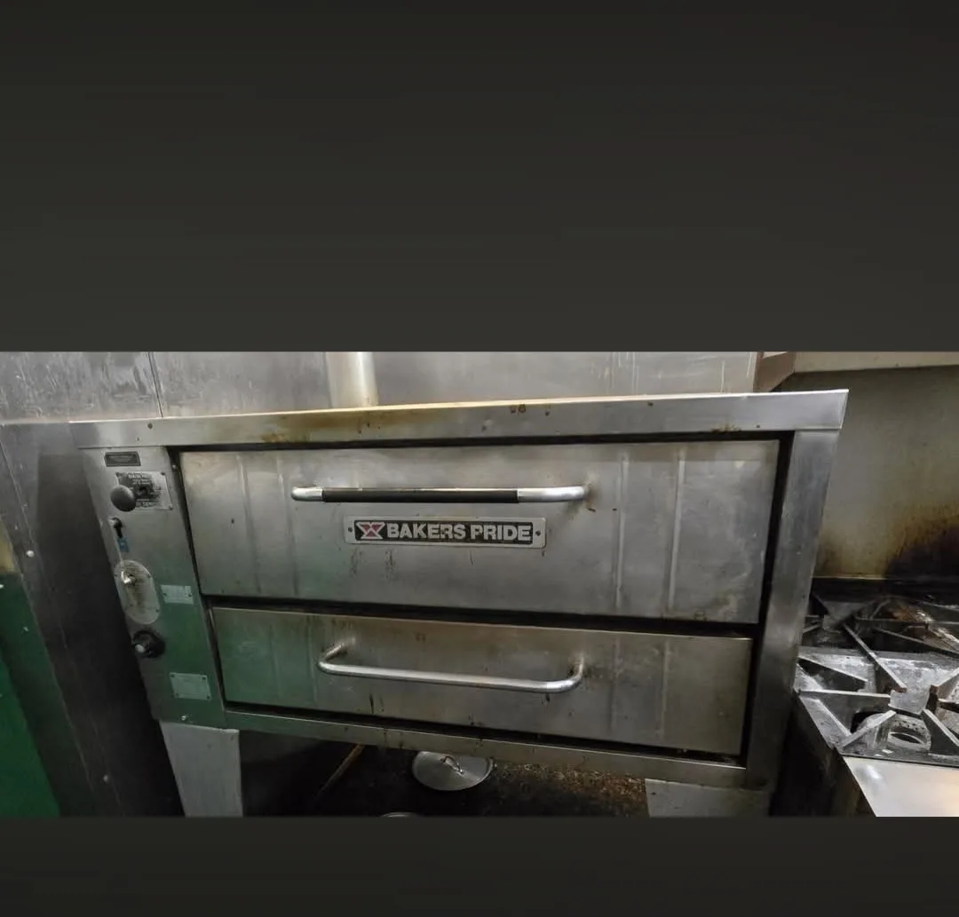 Commercial pizza oven before cleaning with heavy carbon and grease deposits on interior surfaces