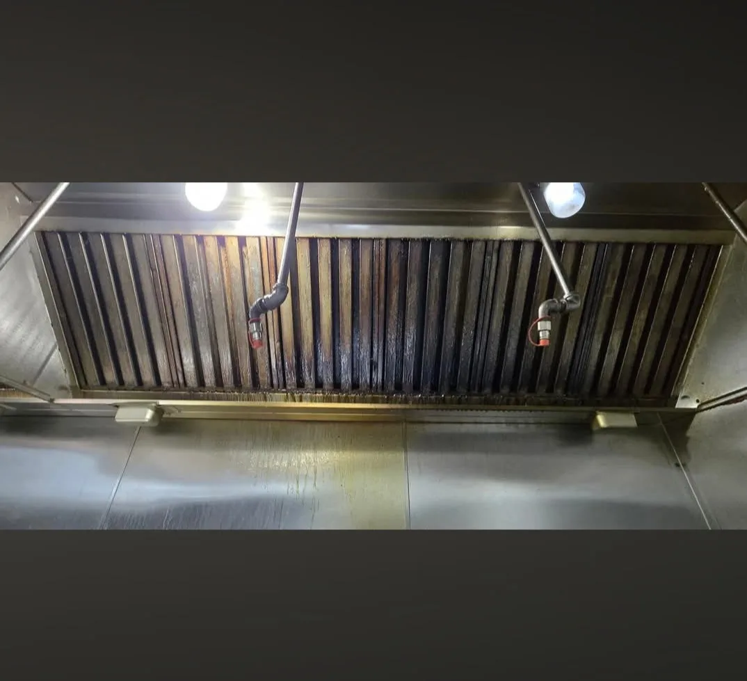Commercial kitchen hood baffle filters before cleaning heavily coated in dark grease