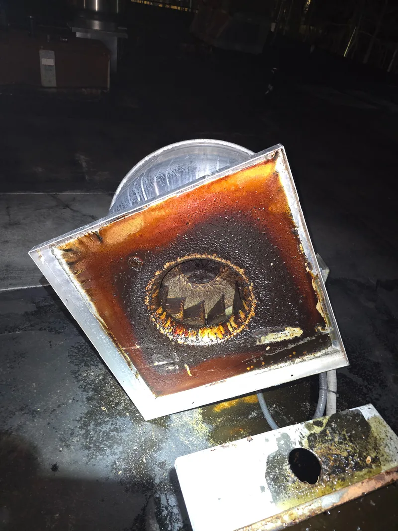 Exhaust system before cleaning showing grease accumulation